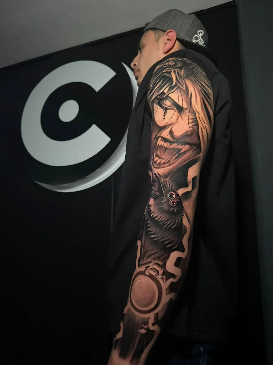 Manga completa en blanco y negro sobre el brazo de un estudiante, frente al logo de Clan Tattoo